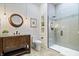 A neutral bathroom with a wooden vanity, decorative mirror, tiled shower with glass door, and neutral wall color at 780 Chatham Hills Blvd, Westfield, IN 46074