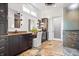 This primary bath features dual vanities with stone counters, beautiful stone flooring, and a glass enclosed shower at 780 Chatham Hills Blvd, Westfield, IN 46074