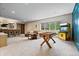 This carpeted game room features a seating area, an arcade game, and a foosball table for fun and entertainment at 780 Chatham Hills Blvd, Westfield, IN 46074