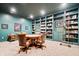 A cozy home library with custom bookshelves, ladder, and a round table at 780 Chatham Hills Blvd, Westfield, IN 46074