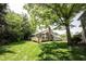 Spacious backyard featuring a well-maintained lawn, mature trees, and a charming deck, ideal for outdoor living at 8023 Talliho Dr, Indianapolis, IN 46256