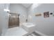 Bright bathroom featuring plank flooring, soaking tub, and glass enclosed shower at 8023 Talliho Dr, Indianapolis, IN 46256