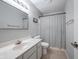 Standard bathroom featuring a toilet, shower with patterned curtain, vanity, and framed mirror at 8023 Talliho Dr, Indianapolis, IN 46256