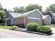 Charming home featuring brick accents, attached garage, manicured lawn, and vibrant flowering shrubbery at 8023 Talliho Dr, Indianapolis, IN 46256