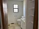 Bright bathroom features a window over the toilet and a sink with white cabinetry, awaiting finishing touches at 812 N California St, Indianapolis, IN 46202