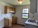 Kitchen with wooden cabinets, double stainless steel sink, and large window at 812 N California St, Indianapolis, IN 46202