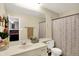 A well-lit bathroom featuring a vanity, toilet, mirror and shower with decorative curtain at 8121 Bromley Pl, Indianapolis, IN 46219