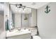 A compact bathroom featuring a sink, toilet, mirror, and a coastal themed decor at 8121 Bromley Pl, Indianapolis, IN 46219