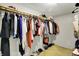 Walk-in closet with wooden rod, shelf for storage and racks filled with assorted clothes and shoes at 8121 Bromley Pl, Indianapolis, IN 46219