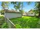 Spacious backyard with green grass, a detached garage, and a chain link fence at 813 Cottage Ave, Columbus, IN 47201