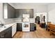 Kitchen features gray cabinets, white appliances, wood flooring, and a view into the next room at 813 Cottage Ave, Columbus, IN 47201