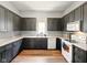 Kitchen with grey cabinets, white appliances, wood flooring, and light countertops at 813 Cottage Ave, Columbus, IN 47201