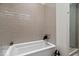 Modern bathroom with subway tile, a white bathtub, and a glass-enclosed shower with upscale fixtures at 855 N East N St # 104-B, Indianapolis, IN 46202