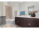 Modern bathroom with a dark wood vanity, white countertop, large mirror, and tiled shower/tub combo at 855 N East N St # 104-B, Indianapolis, IN 46202