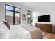 Well-lit bedroom featuring large windows, a dresser and TV, plus sleek hardwood flooring and a modern bed at 855 N East N St # 104-B, Indianapolis, IN 46202