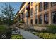 Beautiful exterior of a brick apartment building with walkways, landscaping, benches, and balconies at 855 N East N St # 104-B, Indianapolis, IN 46202
