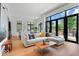 Sun-filled living room with an oversized sofa, floor to ceiling windows, and hardwood floors at 855 N East N St # 104-B, Indianapolis, IN 46202