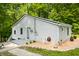 Cozy home featuring light gray siding, a metal roof and inviting entry with Welcome sign, set amidst a lush green backdrop at 8576 Riser Dr, , IN 46164
