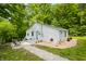 A charming home boasting light gray siding, a durable metal roof, a warm 'Welcome' sign, and surrounded by a verdant setting at 8576 Riser Dr, , IN 46164