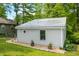 The additional building includes gray siding, metal roof, round window detail, planters and mulch landscaping at 8576 Riser Dr, , IN 46164