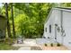 Side view of a home showcasing light gray siding, a metal roof, and a cozy patio area with outdoor seating at 8576 Riser Dr, , IN 46164