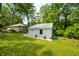 The additional building includes gray siding, a metal roof, round window detail, planters, and mulch landscaping at 8576 Riser Dr, , IN 46164