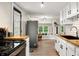 Bright kitchen features white cabinets, butcher block countertops, stainless steel appliances, and a view to the living area at 8576 Riser Dr, , IN 46164