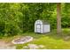 A charming storage shed sits beside a fire pit in a treed yard at 8576 Riser Dr, , IN 46164