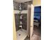 This accessible shower features gray tiling, a built-in caddy, and a nearby bedroom with a decorative bed frame at 8926 Durban Ct, Indianapolis, IN 46234