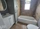 Cozy bathroom featuring a tub/shower combination, tiled walls, and a vanity with storage at 927 Cecil Ave, Indianapolis, IN 46219