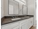 Bathroom featuring double sinks, dark counters, and white cabinets at 9949 Nightsong Ln, Avon, IN 46123