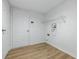 Bright laundry room with modern light-wood-look flooring and white walls at 9949 Nightsong Ln, Avon, IN 46123