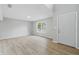 Bright open-plan living room featuring wood-look flooring, a large window, and a white interior door at 9949 Nightsong Ln, Avon, IN 46123