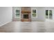 Spacious living room with a brick fireplace, wood flooring, and bright natural light at 9949 Nightsong Ln, Avon, IN 46123