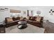 Spacious living room with a comfortable leather sectional, a round coffee table, and ample natural light at 10118 Falls Canyon Ln, Indianapolis, IN 46229