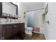 Bright bathroom features dark wood cabinets, a granite countertop, framed mirror, and shower with blue curtain at 10262 Carmine Dr, Noblesville, IN 46060