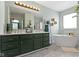 Elegant bathroom featuring a double vanity, sleek countertops, and a freestanding tub offering a luxurious spa-like experience at 10262 Carmine Dr, Noblesville, IN 46060