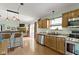 An open kitchen with wooden cabinets, stainless appliances, seamlessly connects to the living area with a breakfast bar at 10262 Carmine Dr, Noblesville, IN 46060