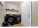 Well-lit laundry room features two black front-loading machines, white walls, and sleek wooden floors at 10262 Carmine Dr, Noblesville, IN 46060