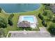 This aerial shot showcases a community pool and clubhouse near a serene lake, surrounded by lush greenery at 10262 Carmine Dr, Noblesville, IN 46060