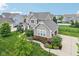 Aerial view of a two-story home featuring a manicured lawn, landscaping, and a private driveway at 10806 Solis Cir, Fishers, IN 46038