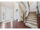Inviting foyer with a staircase featuring a wood banister and carpeted steps, and a white front door at 10806 Solis Cir, Fishers, IN 46038