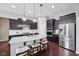 Modern kitchen with stainless steel appliances, granite countertops, dark wood cabinets and a large island with seating at 10806 Solis Cir, Fishers, IN 46038
