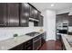 Well-equipped kitchen featuring stainless steel appliances, granite countertops, and dark wood cabinets at 10806 Solis Cir, Fishers, IN 46038