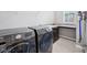 Functional laundry room featuring a washer, dryer, a sink, and ample counter space with storage cabinets at 10806 Solis Cir, Fishers, IN 46038