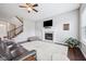 Comfortable living room with a fireplace, ceiling fan, and a view of the staircase to the second level at 10806 Solis Cir, Fishers, IN 46038