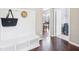 Mud room featuring a bench with storage, coat hooks, hardwood floors, and views of the dining and laundry room at 10806 Solis Cir, Fishers, IN 46038