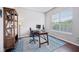 Bright office featuring a wooden desk, a rolling chair, and a blue patterned rug on hardwood floors at 10806 Solis Cir, Fishers, IN 46038