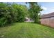 Spacious backyard view of home, trees and partial view of a neighbor's home at 1106 N Sheffield Ave, Indianapolis, IN 46222