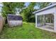 View of the backyard featuring the sunroom addition and a storage shed at 1106 N Sheffield Ave, Indianapolis, IN 46222